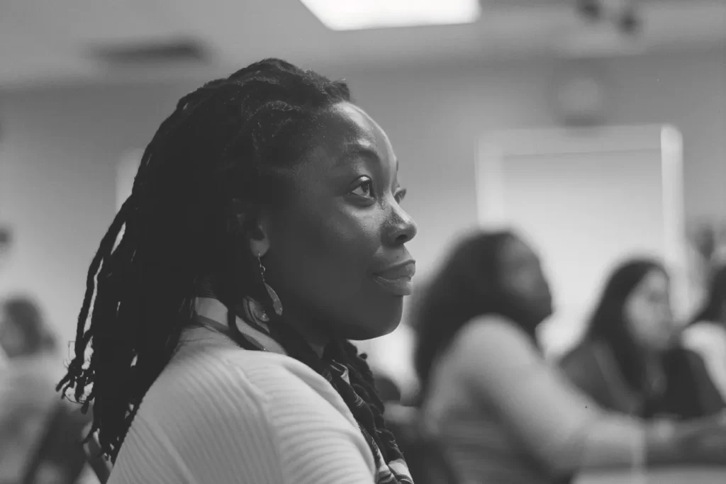 Attentive woman with dreadlocks listening in a meeting.
